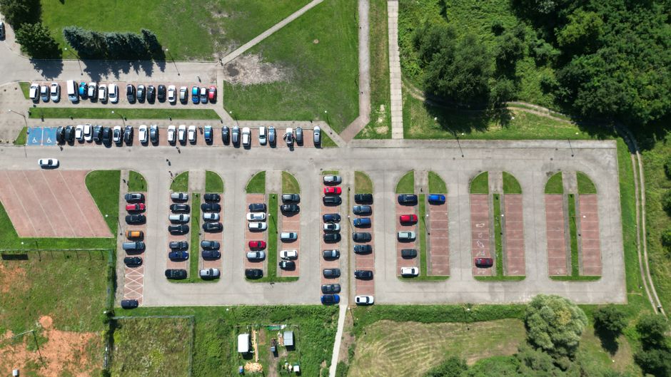 Sürücü park yeri seçeneklerini karşılaştırırken rota planı üzerinde düşünceli bir görünüm