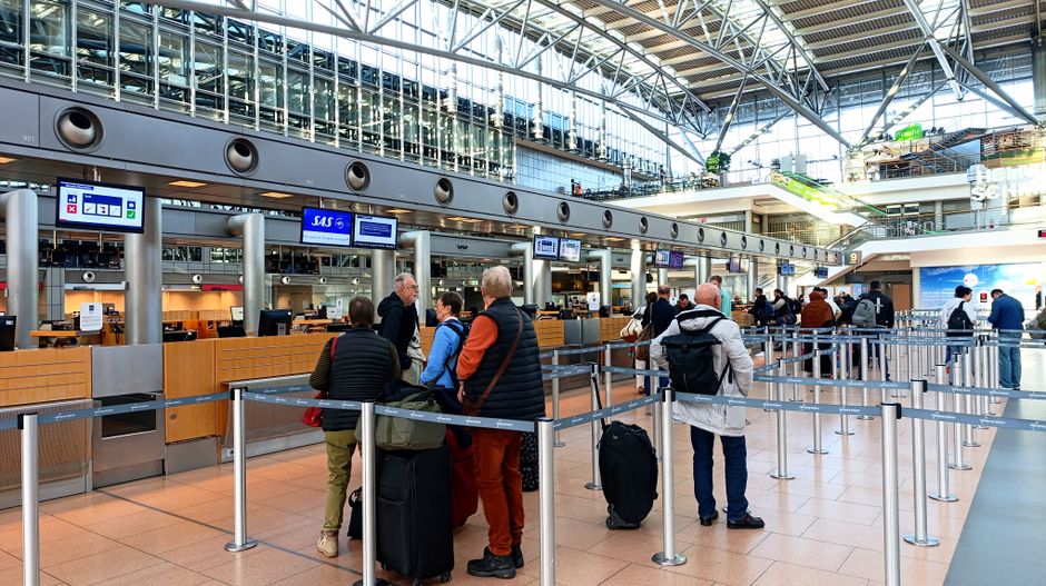 Bir yolcu boarding kartını kontrol noktası önünde gösteriyor